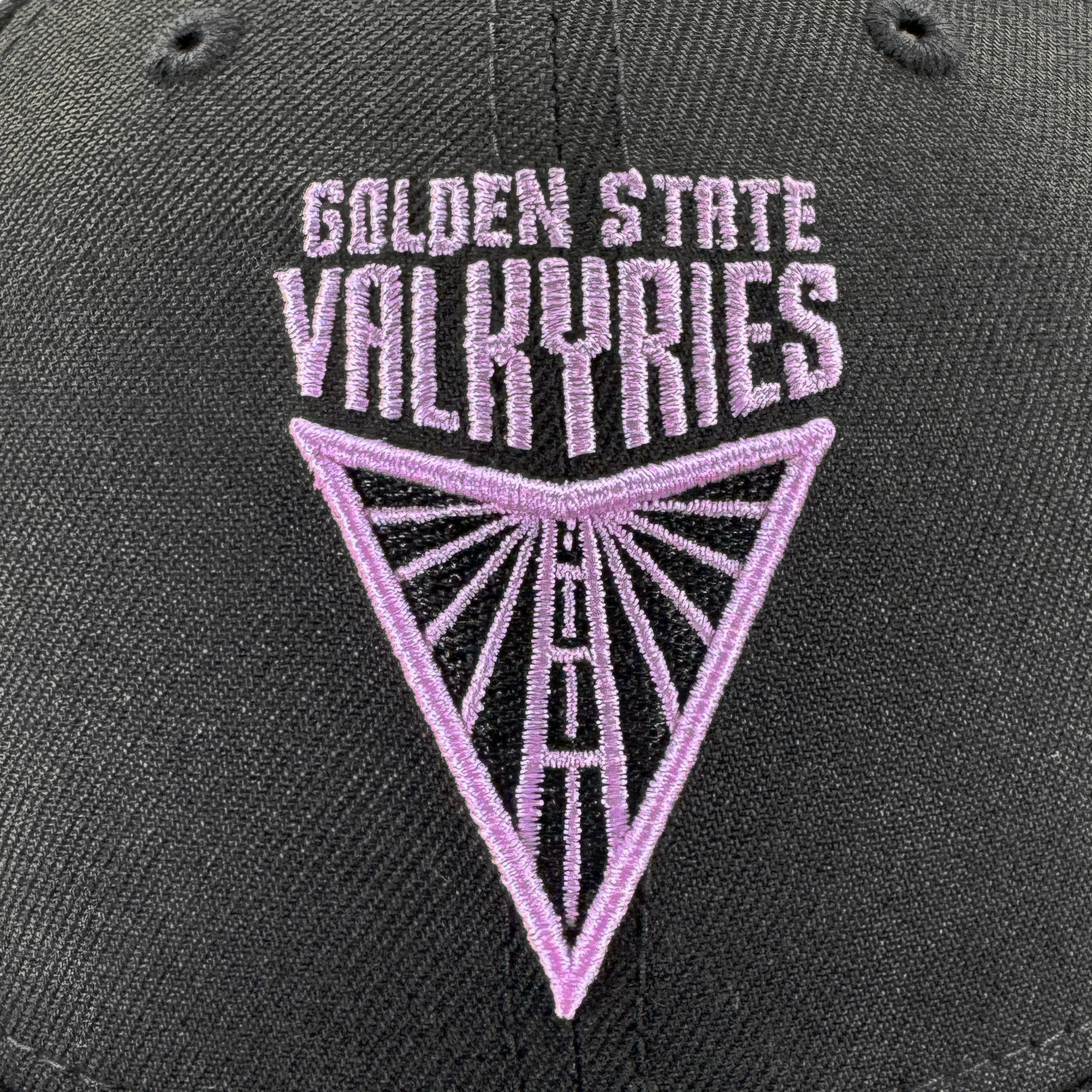 Close-up of the GSV Logo 9FORTY Snapback by GSV, a black hat with purple "GOLDEN STATE VALKYRIES" embroidery above a geometric, radiant inverted triangle logo.
