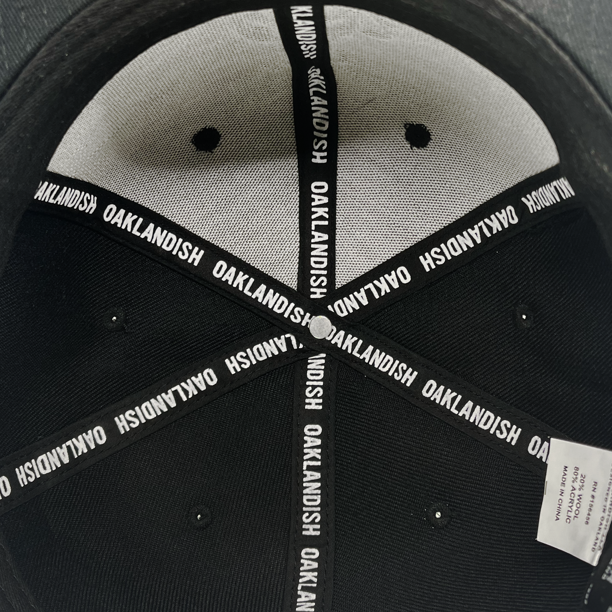 Detailed close up of Oaklandish taping inside the crown of black cap.