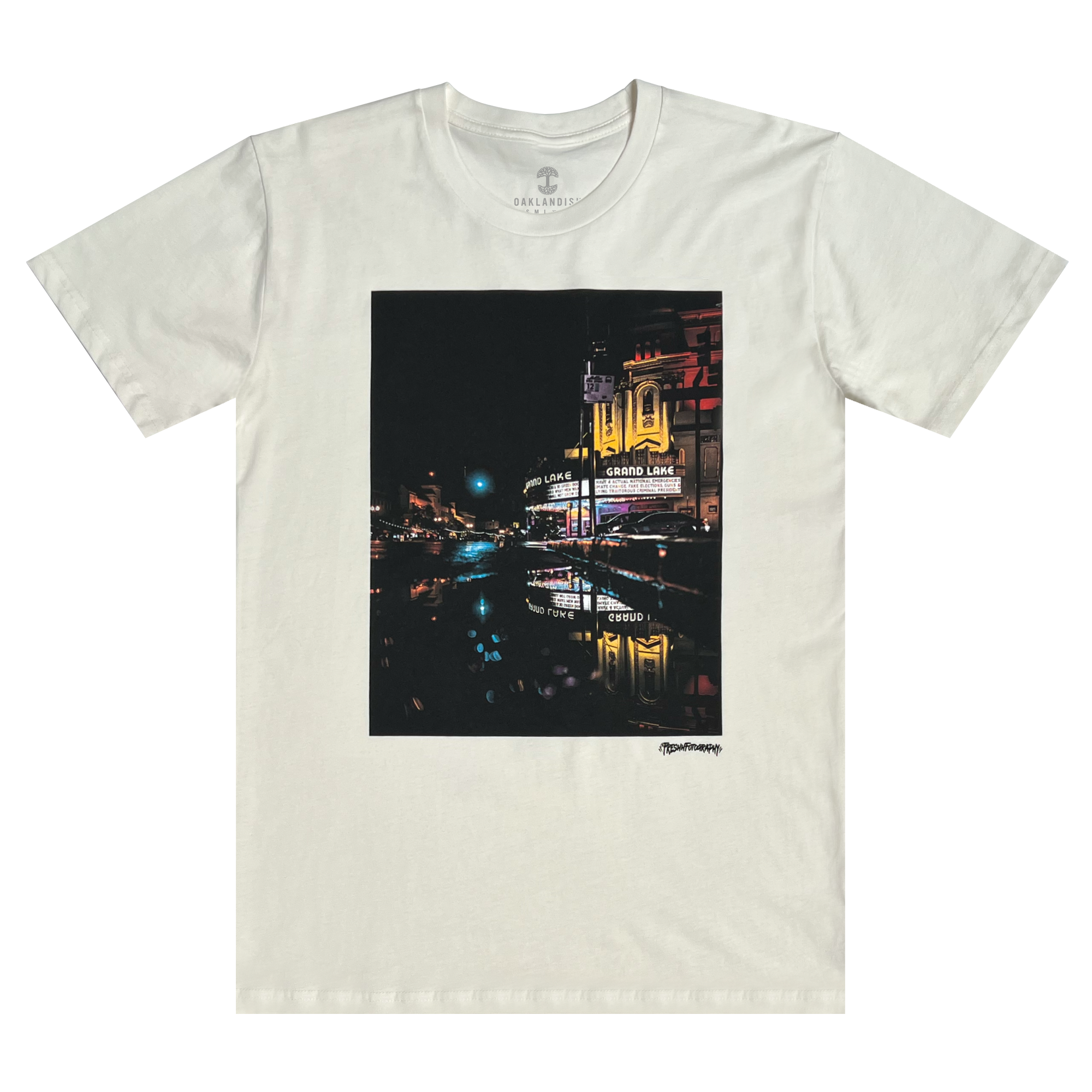 Front view of a natural cotton t-shirt with an image of a rainy night reflecting street lights and The Grand Laker Theatre in Oakland.