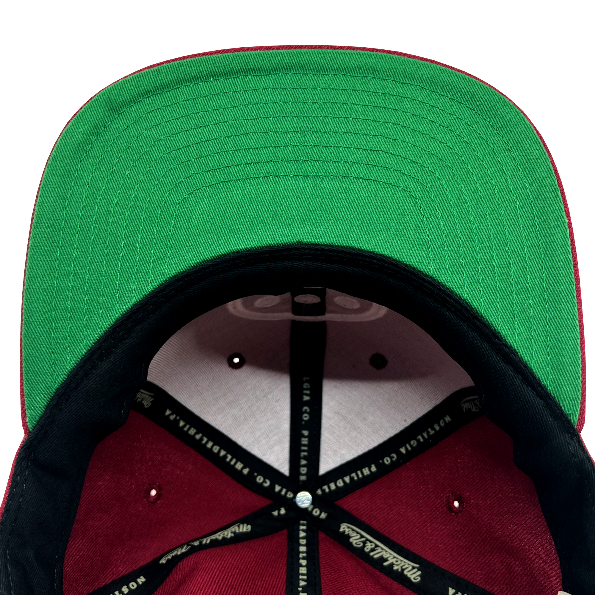 Detailed close-up of green undervisor and taping inside the crown of a Hiero hip hop X Mitchell & Ness cap.