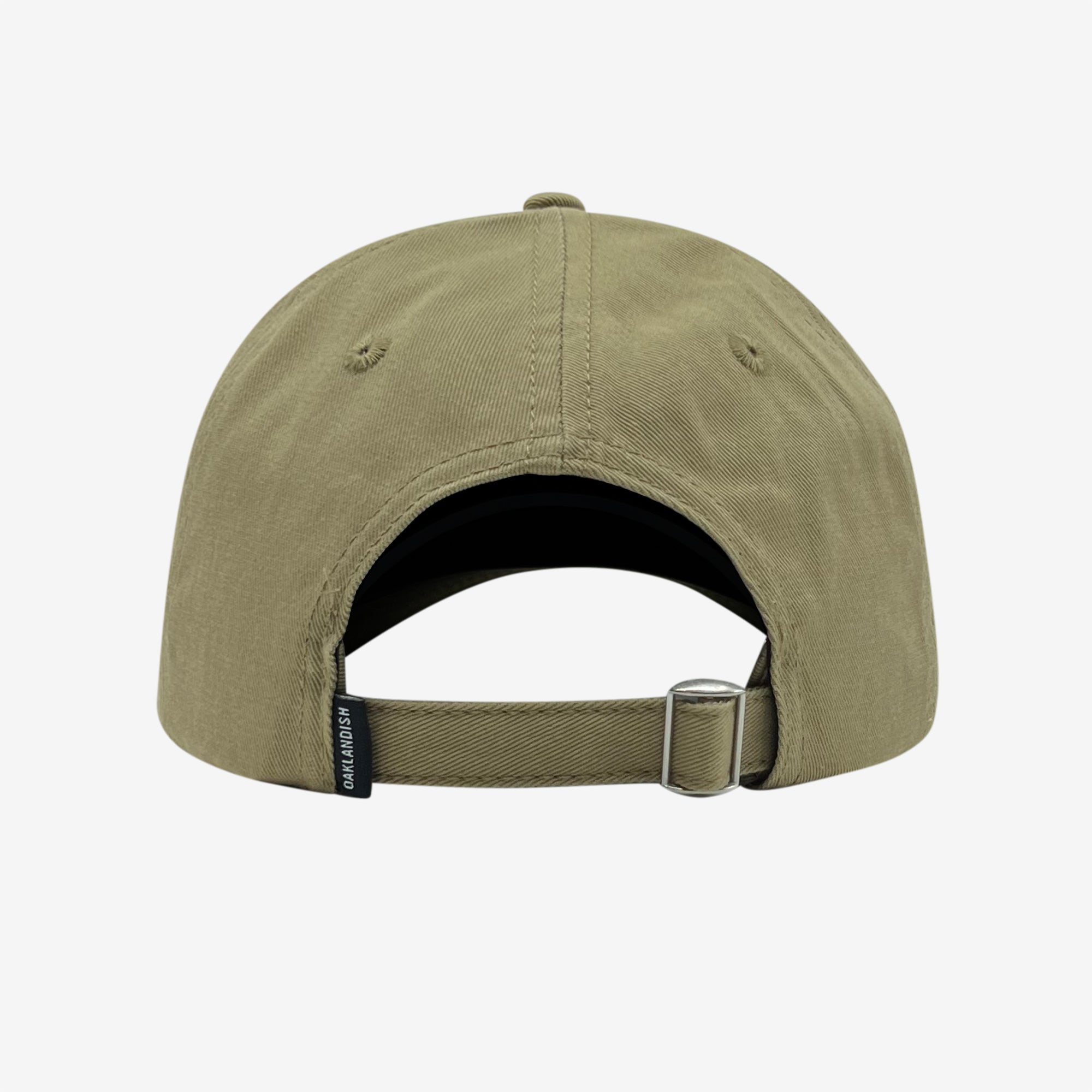 The image shows the back of the olive green Official Micro Logo Dad Hat from Oaklandish. It features an adjustable strap with a metal buckle and a small black tag with text next to the strap. The strap can be extended or shortened for a better fit, and the cap has two stitched eyelets on each side for ventilation.