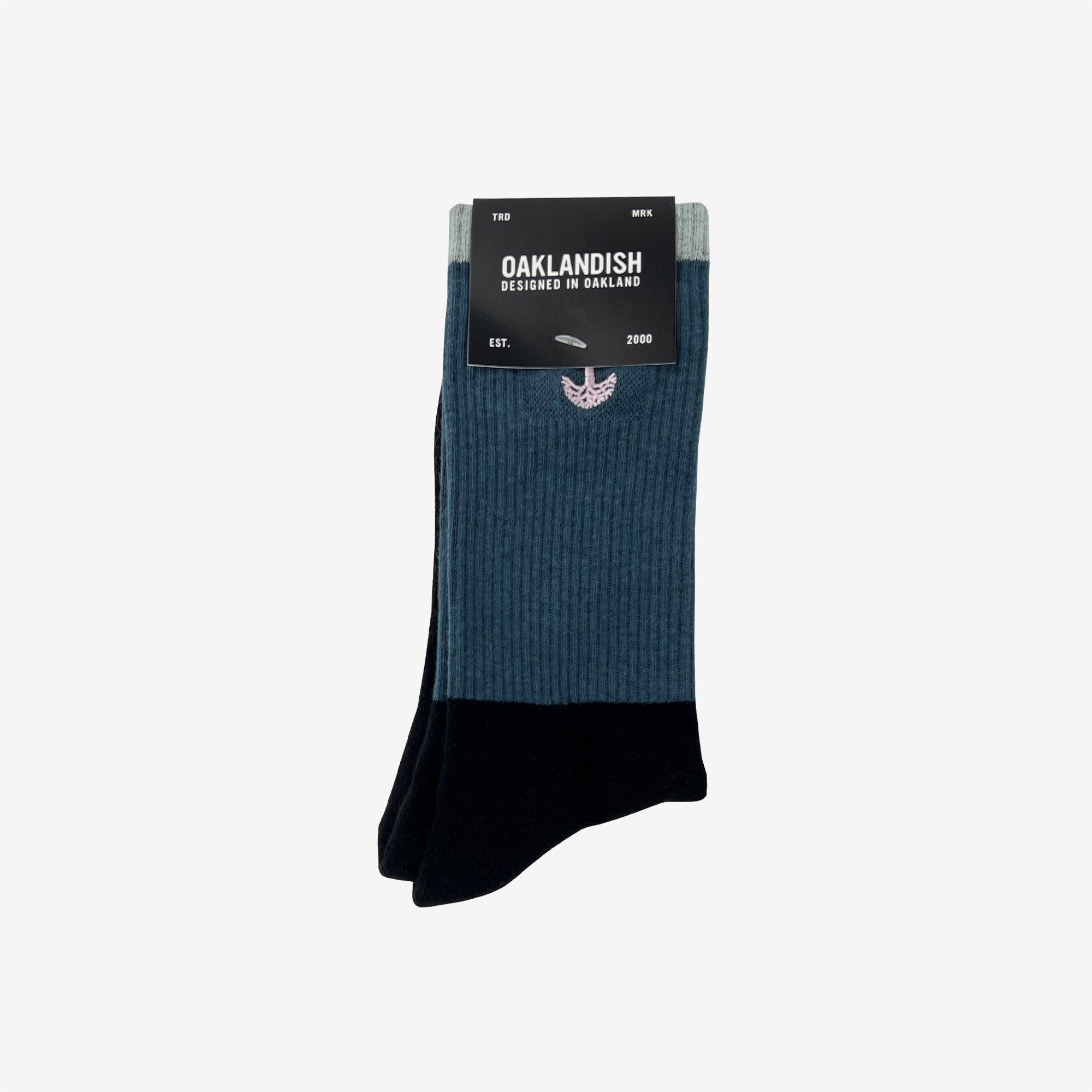 High-cut color blocked crew socks folded into an Oaklandish retail package.