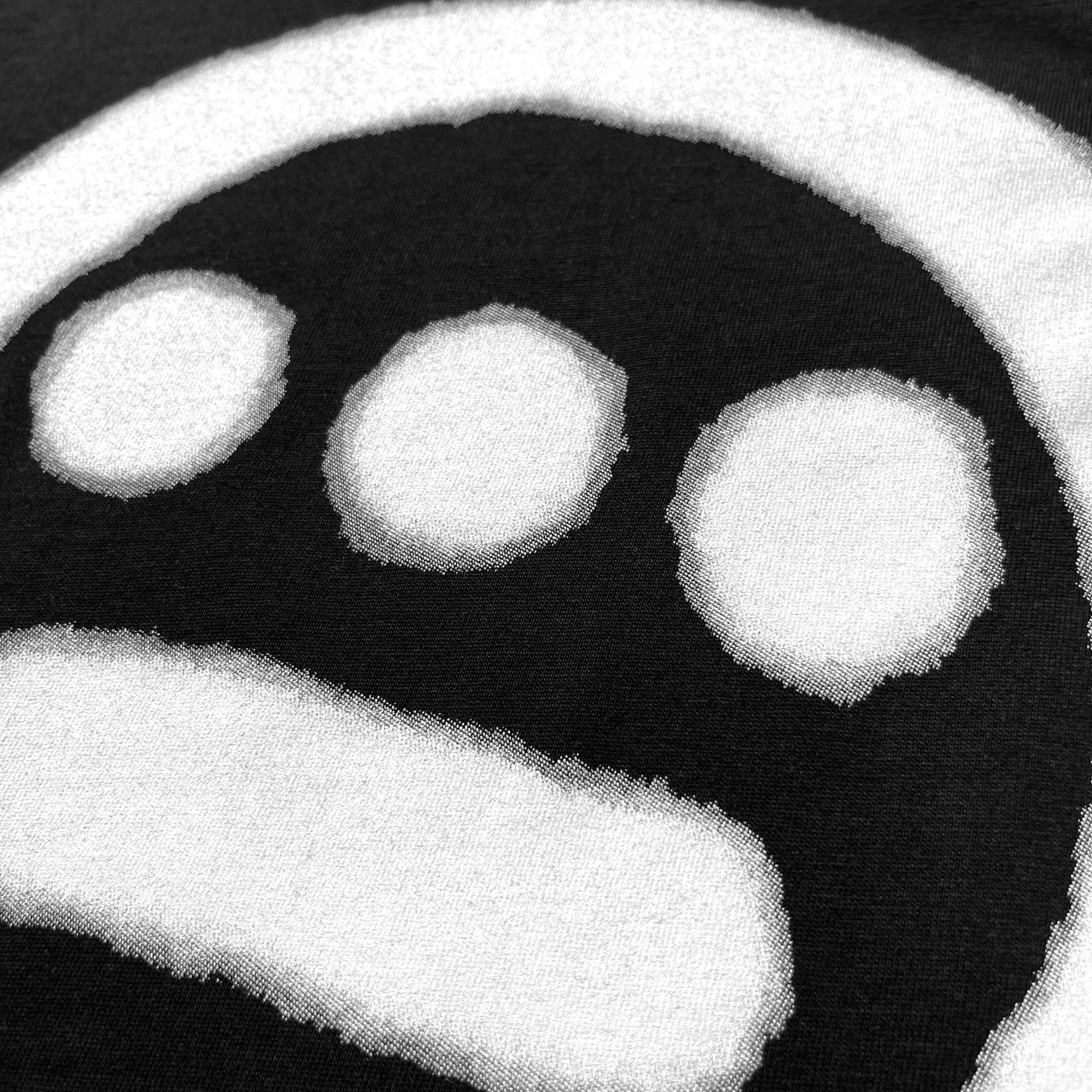 Close up of spray-painted Hieroglyphics hip-hop logo on the chest of a black t-shirt.