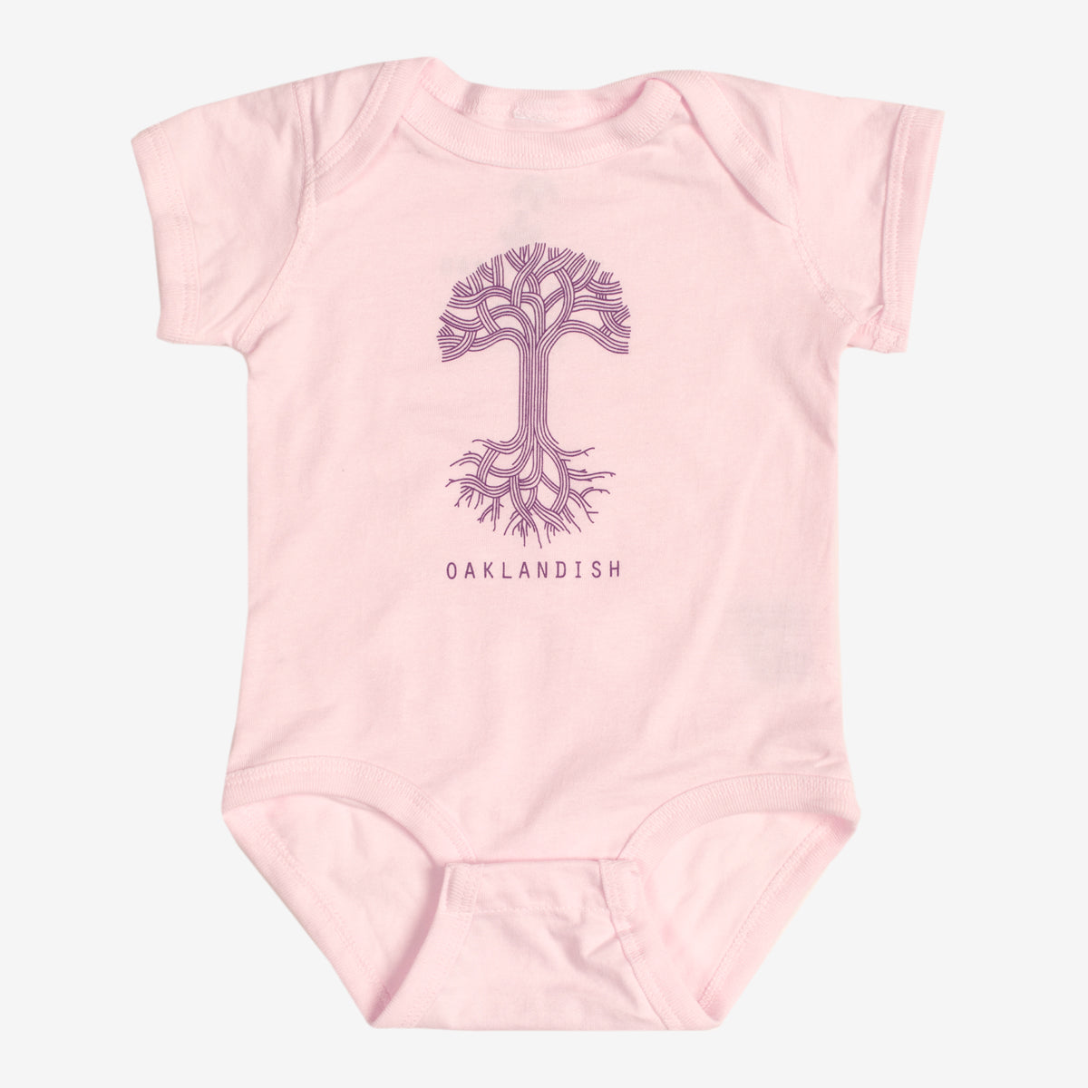 The Infant Oaklandish Classic Logo One-Piece by Oaklandish is a pink, short-sleeve baby romper made from 100% cotton. It showcases a line-drawn image of a tree with intricate branches and roots at the center, with "OAKLANDISH" prominently printed in bold capital letters below the tree. The onesie is displayed on an unadorned white background.