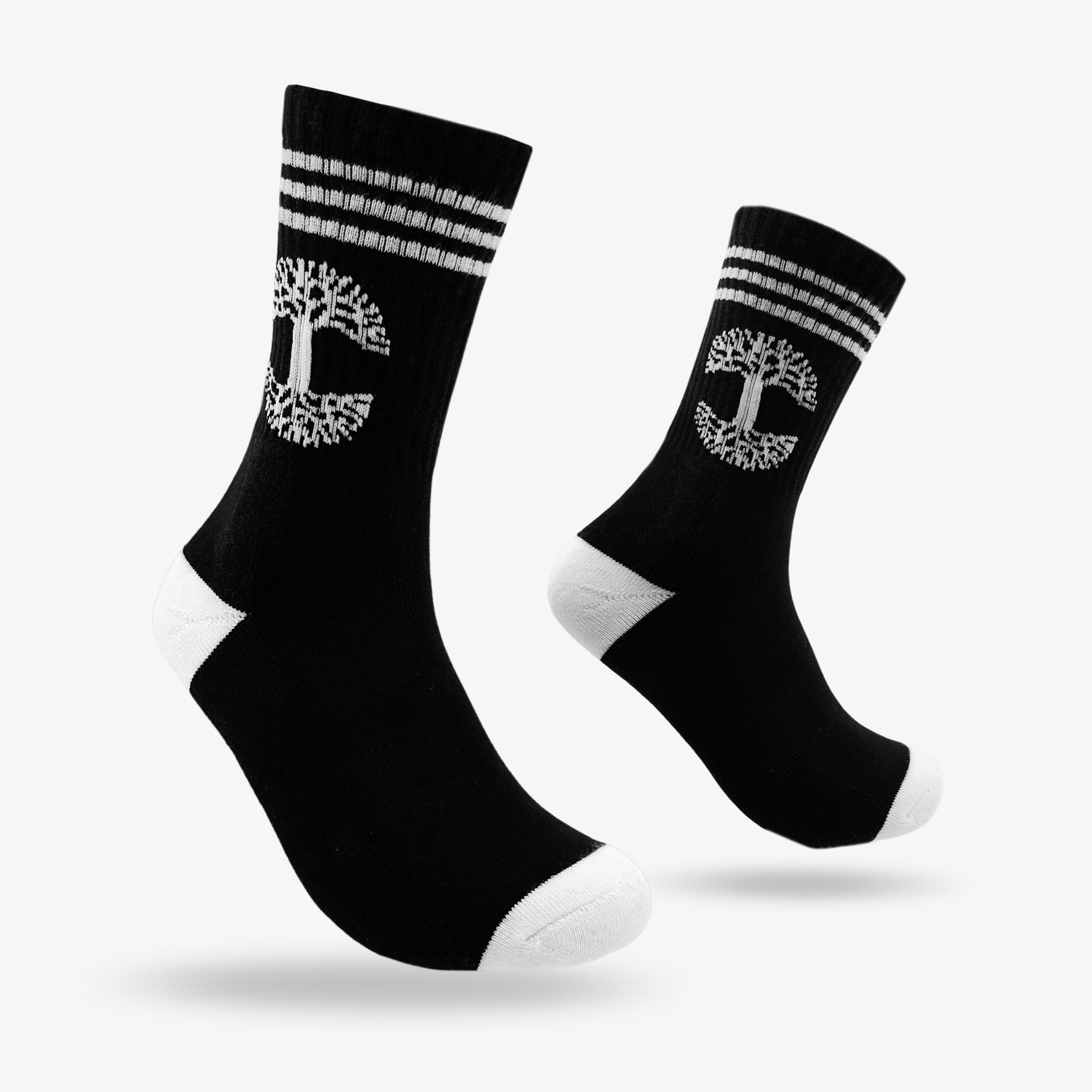 A pair of Retro Classic Socks by Oaklandish, designed in black with three white stripes at the top and a distinctive tree-like Oaklandish logo encased in a circular border. The toes and heels, also white, provide a striking contrast. These exceptionally comfy mid-calf socks are displayed side by side, angled slightly with toes pointing upward against a plain white background.