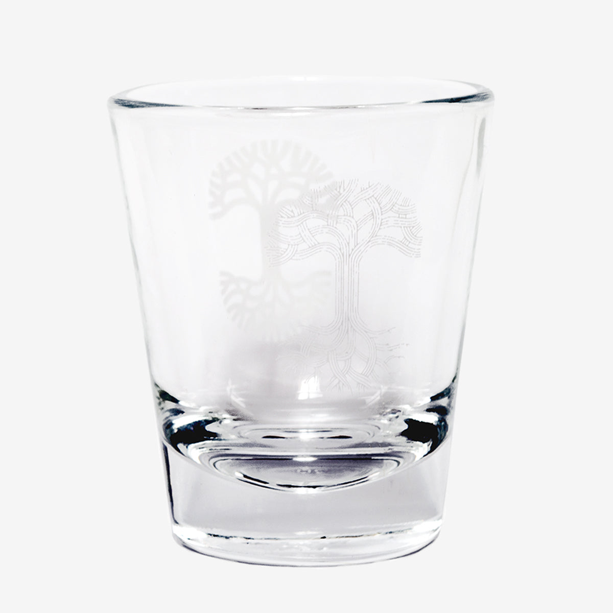 Clear glass liquor shot glass with translucent Oaklandish tree logo. 