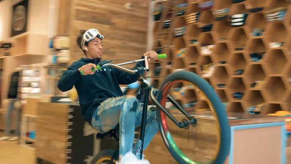 Lamar (bicyclist) popping a wheelie inside the Oaklandish Downtown store.