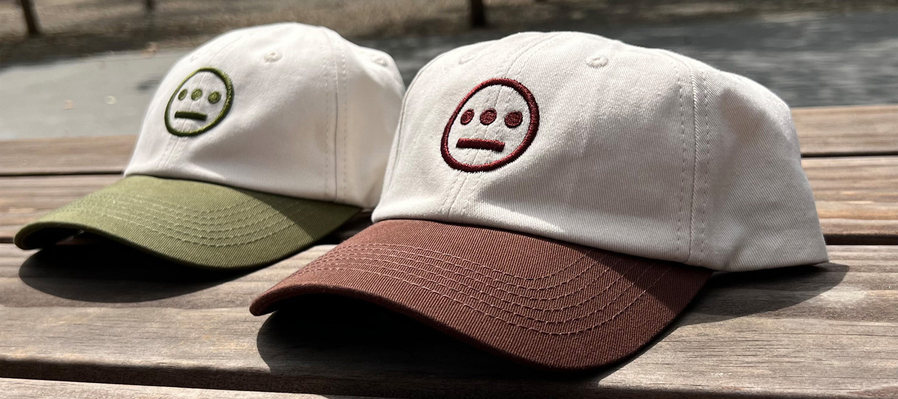 Photo image (left to right) of cream with olive logo and cream with brown logo dad hats with contrasting brims and embroidered logo