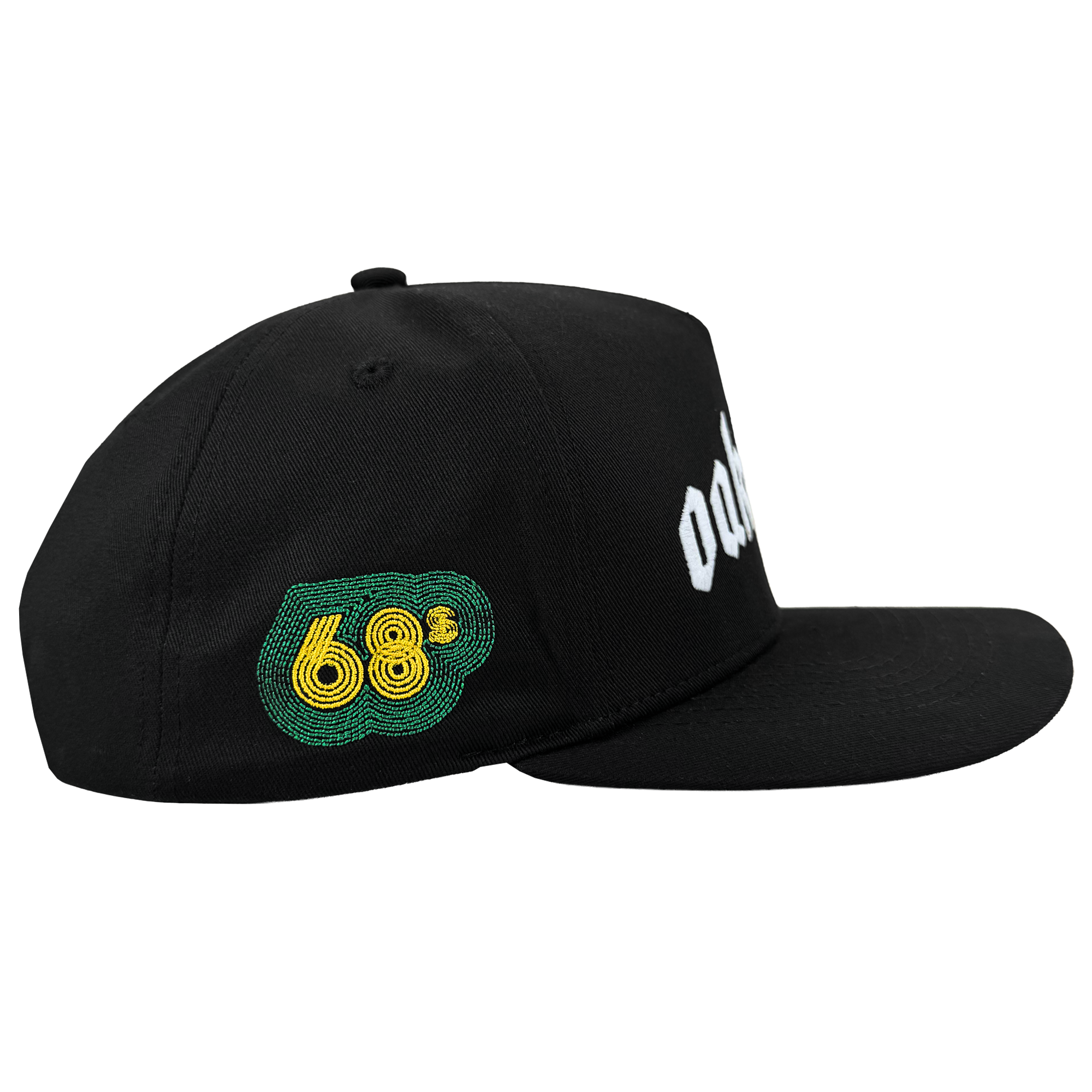 The Oaklandish Oakland 68s Panel Cap is a black snapback hat with a flat brim, structured crown, green and yellow embroidered “68” on the left panel, partially visible white text on the front, shown from the side on a white background.