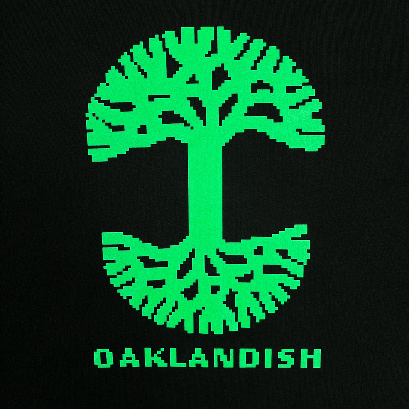 Detailed close-up of retro green Oaklandish tree logo and wordmark on a black t-shirt.