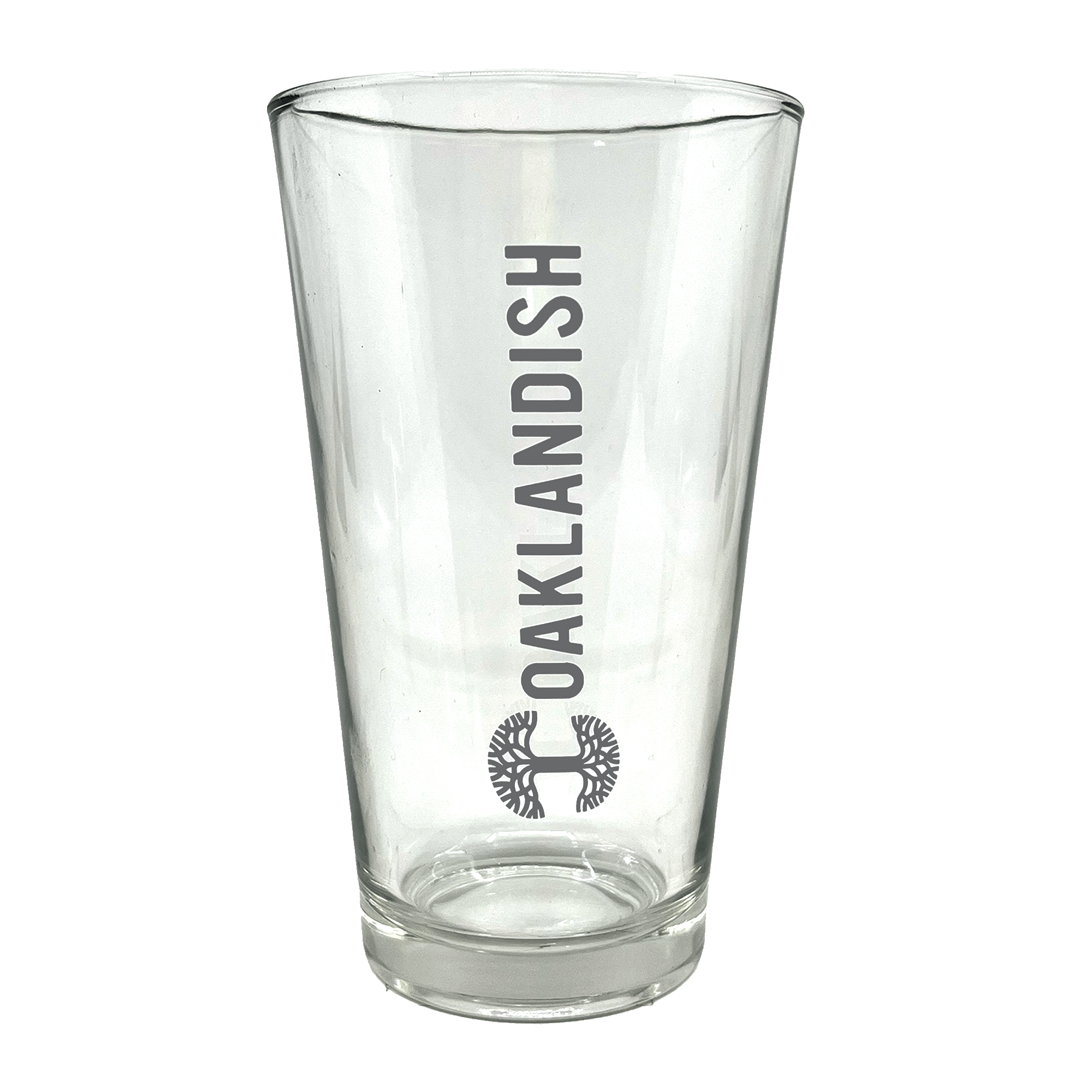 Clear 16 oz glass beer pint glass with dark grey Oaklandish logo and wordmark imprint.