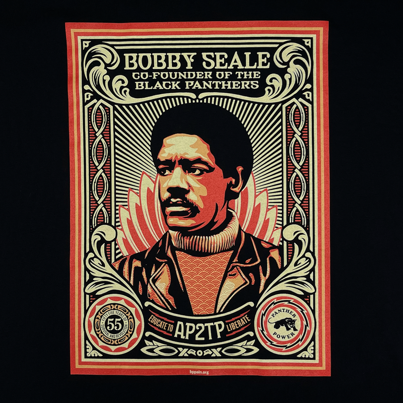 Close-up of a large illustrated multi-colored graphic by Shepard Fairey, founder of Black Panthers, on a black limited edition t-shirt. 