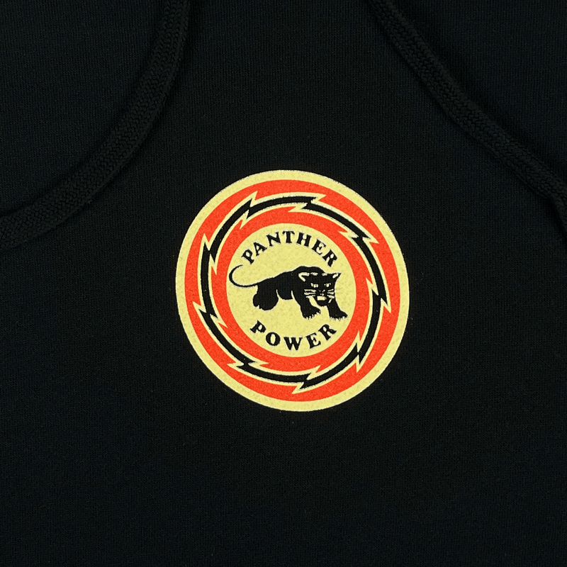 Close-up of small Panther Power circle graphic on the front of black limited edition hoodie.