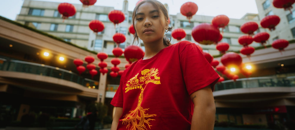 Female model wearing Dragon Power t-shirt in red with gold artwork design.