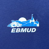 Close-up of EBMUD wordmark and centennial celebration graphic on right chest wear side of blue t-shirt.