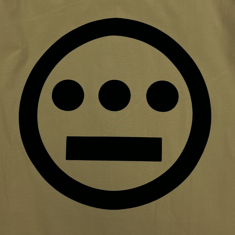 Close up of Hiero logo printed in black ink on backside of an khaki coaches jacket.