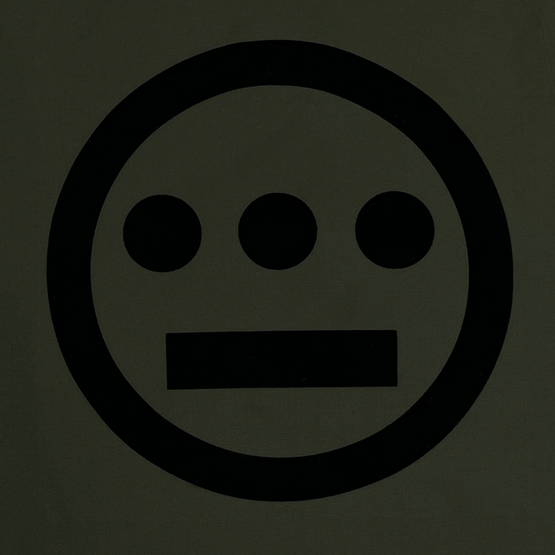 Close up of Hiero logo printed in black ink on backside of an Olive coaches jacket.