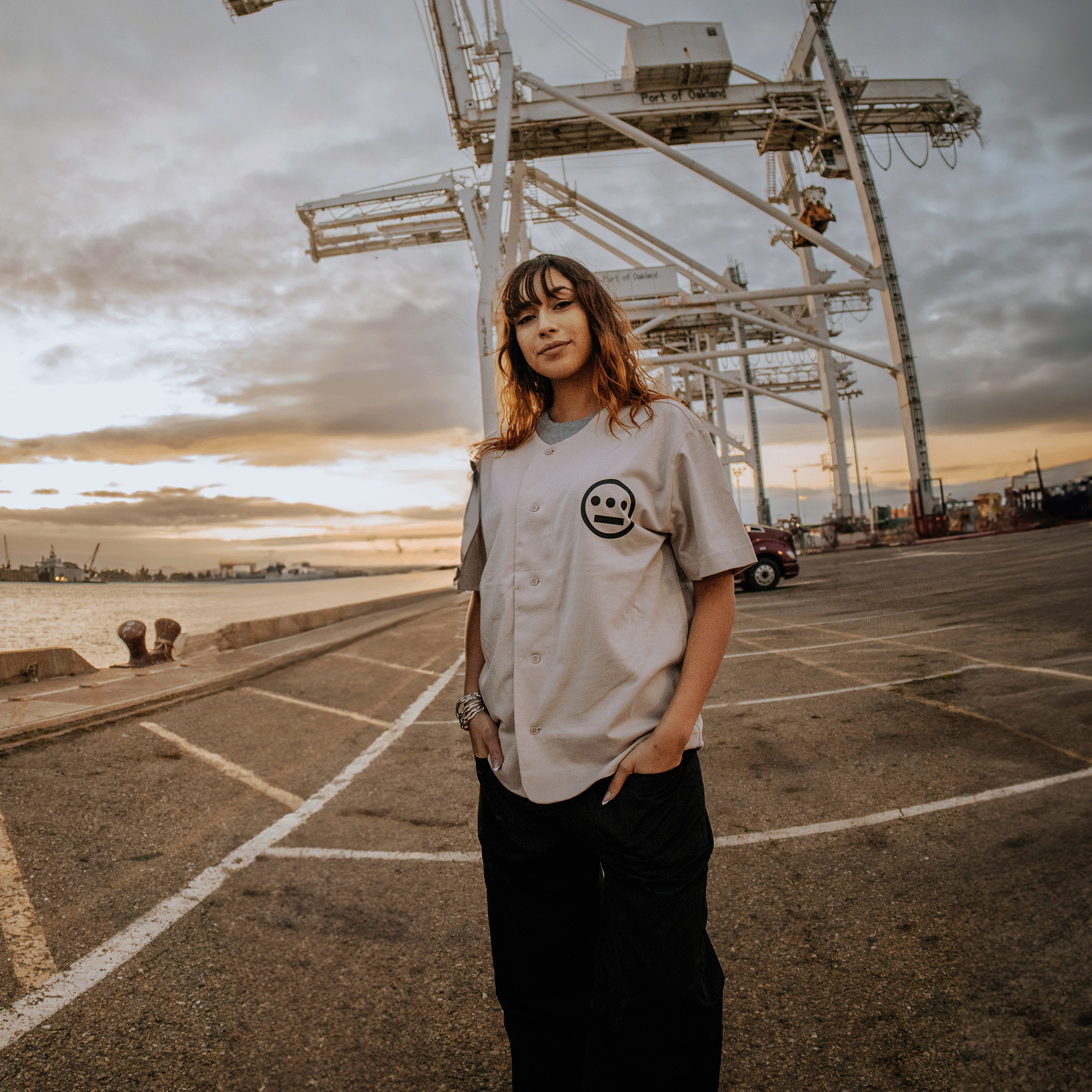 Female model wearing Bone-colored button-up baseball jersey with black Hieroglyphics Hip Hop logo on left chest.