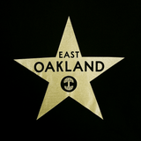 Close up of gold East Oakland walk of fame star from Casita restaurant on a black t-shirt..