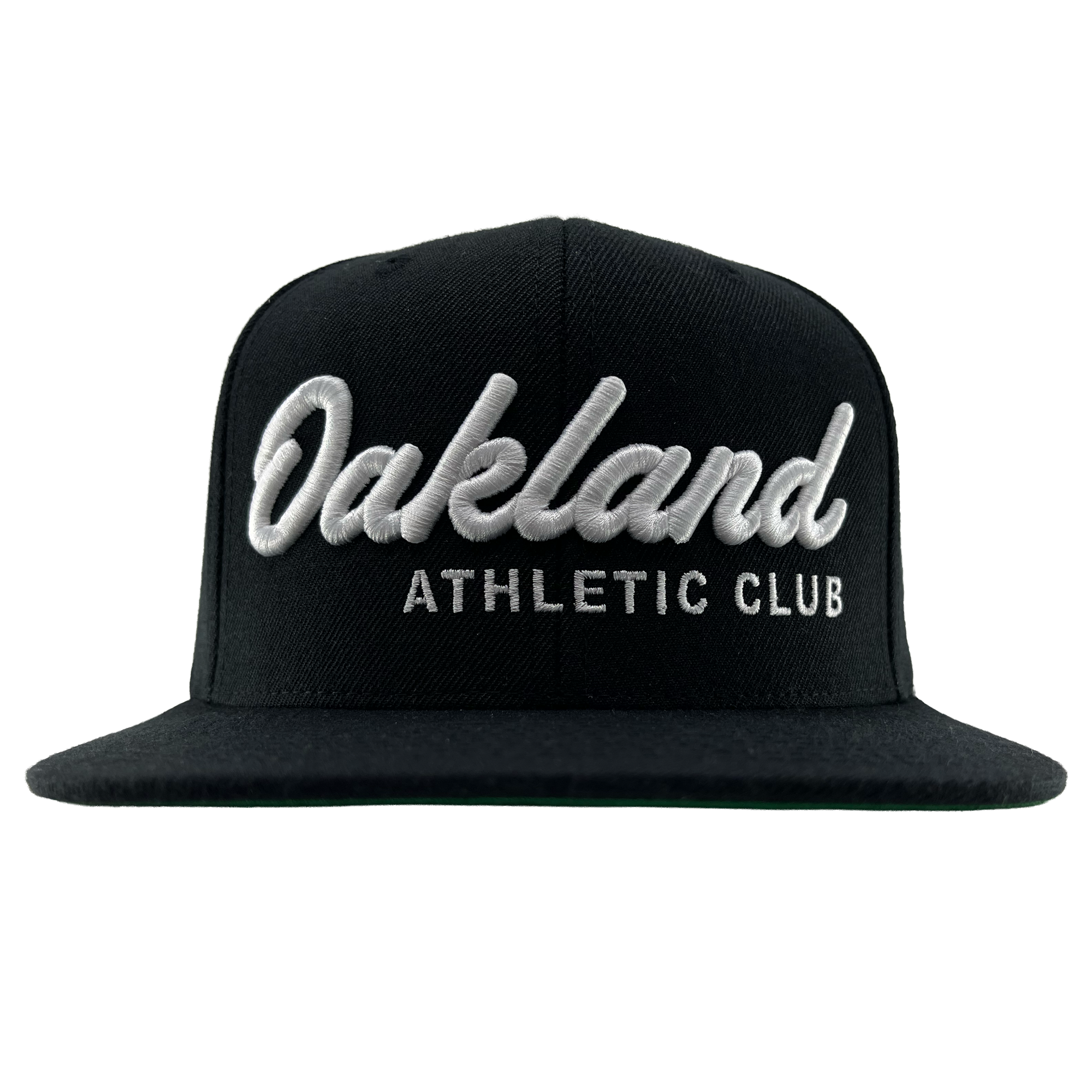 The OAC Script Snapback by OAC is a black flat-brimmed, adjustable cap featuring bold white cursive “Oakland” lettering above smaller block “ATHLETIC CLUB” text on the front, standing out against a plain white background.