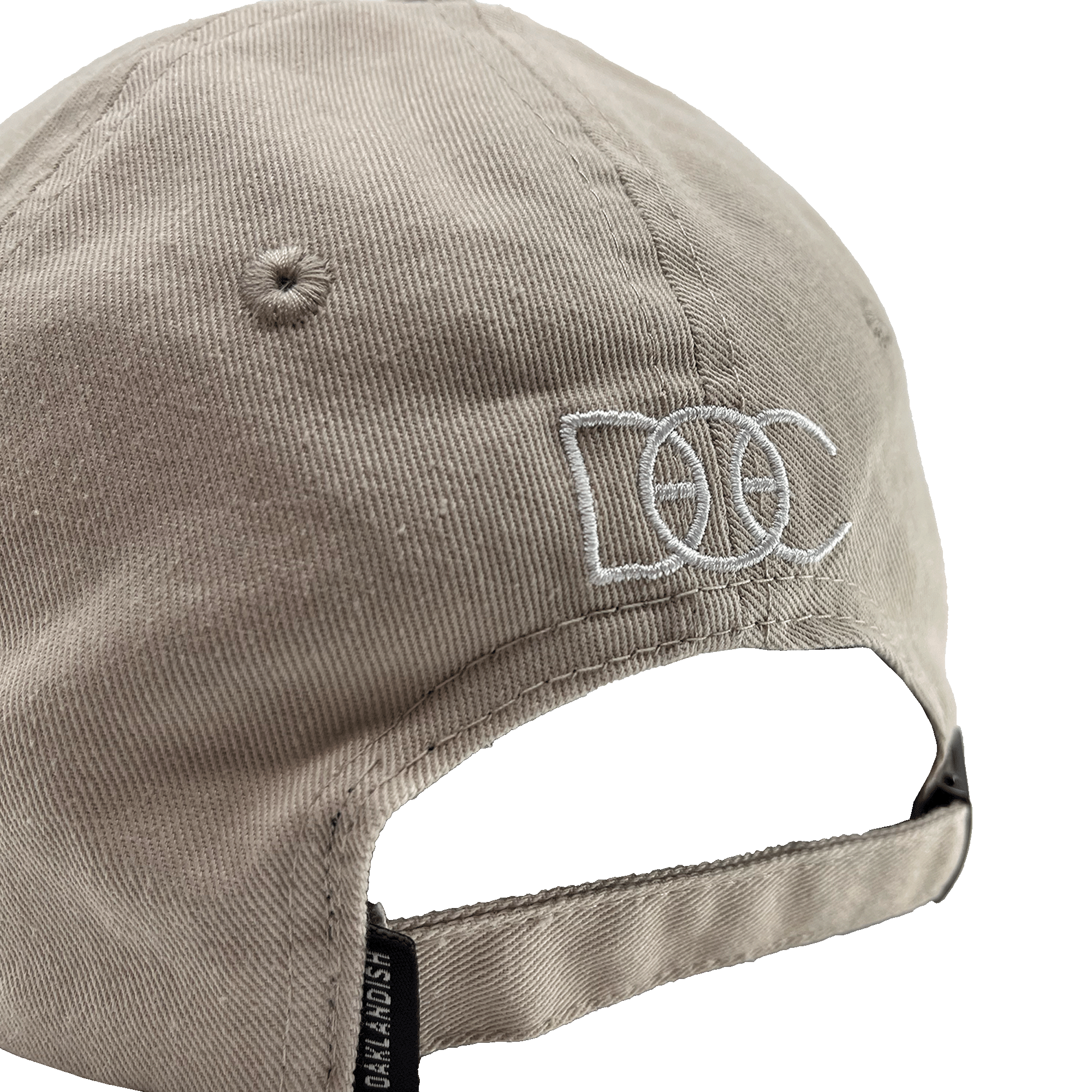 Angled back view of khaki Oakland Dad Hat designed by Dustin O. Canalin white embroidered DOC wordmark, adjustable strapback, and small Oaklandish wordmark tag.