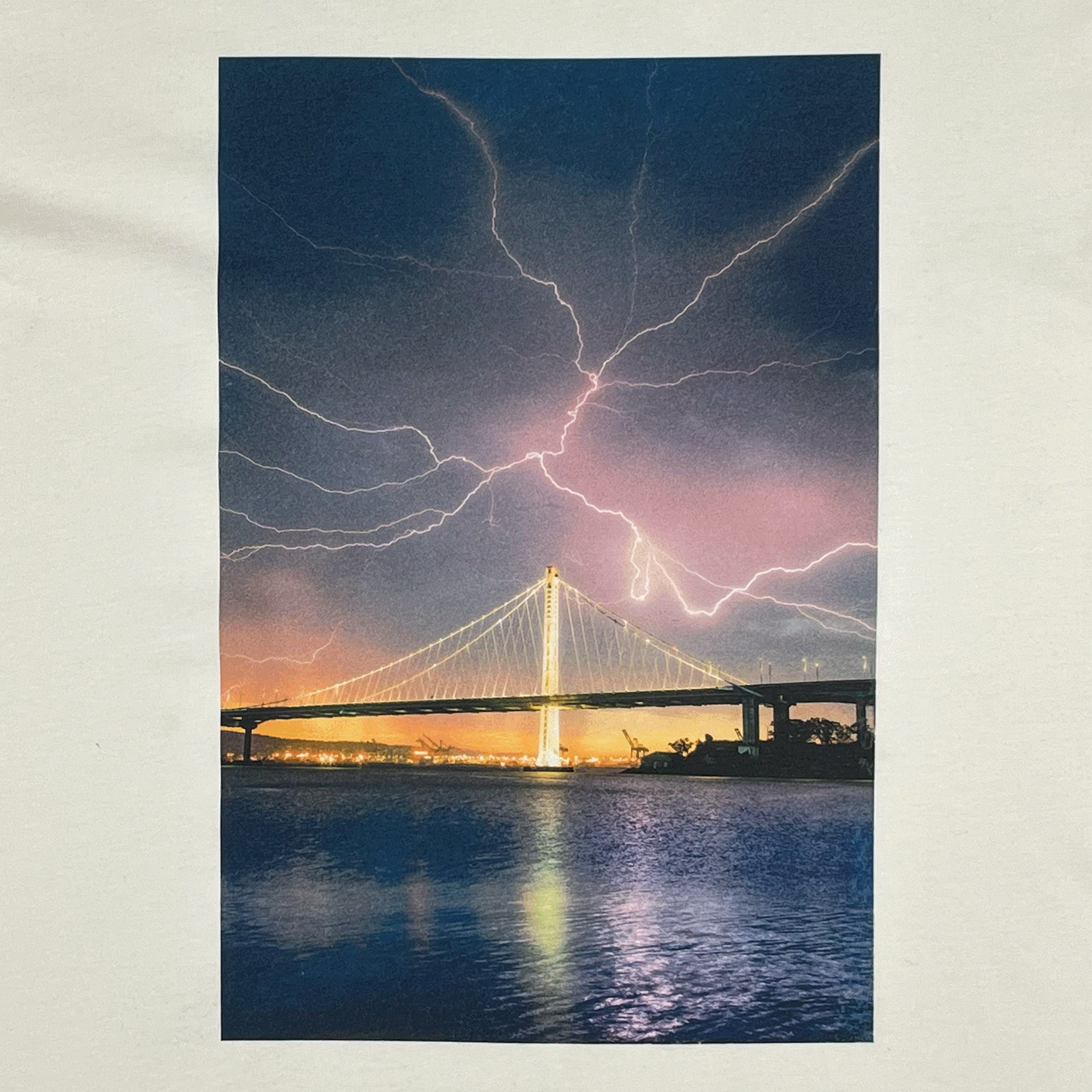 Close up of a photo of lightning over Bay Bridge in Oakland on natural cotton colored t-shirt.