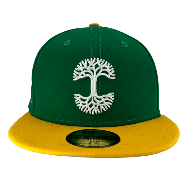 Green New Era cap with yellow bill and a white embroidered Oaklandish tree logo on the crown.