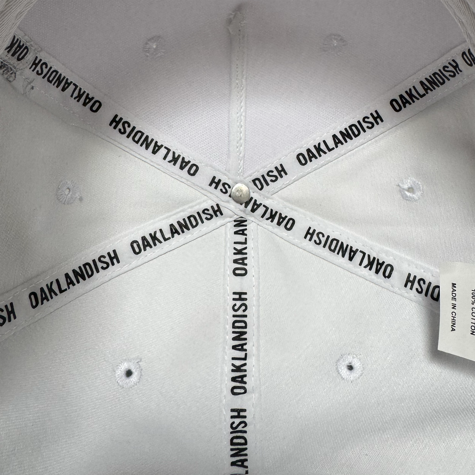 Close-up view of the inside crown of the Oakland Ballers 5 Panel Cap. Black “OAKLAND BALLERS” text repeats on interior fabric bands, evoking Oakland baseball spirit. Visible are white stitching and a “MADE IN CHINA” tag.