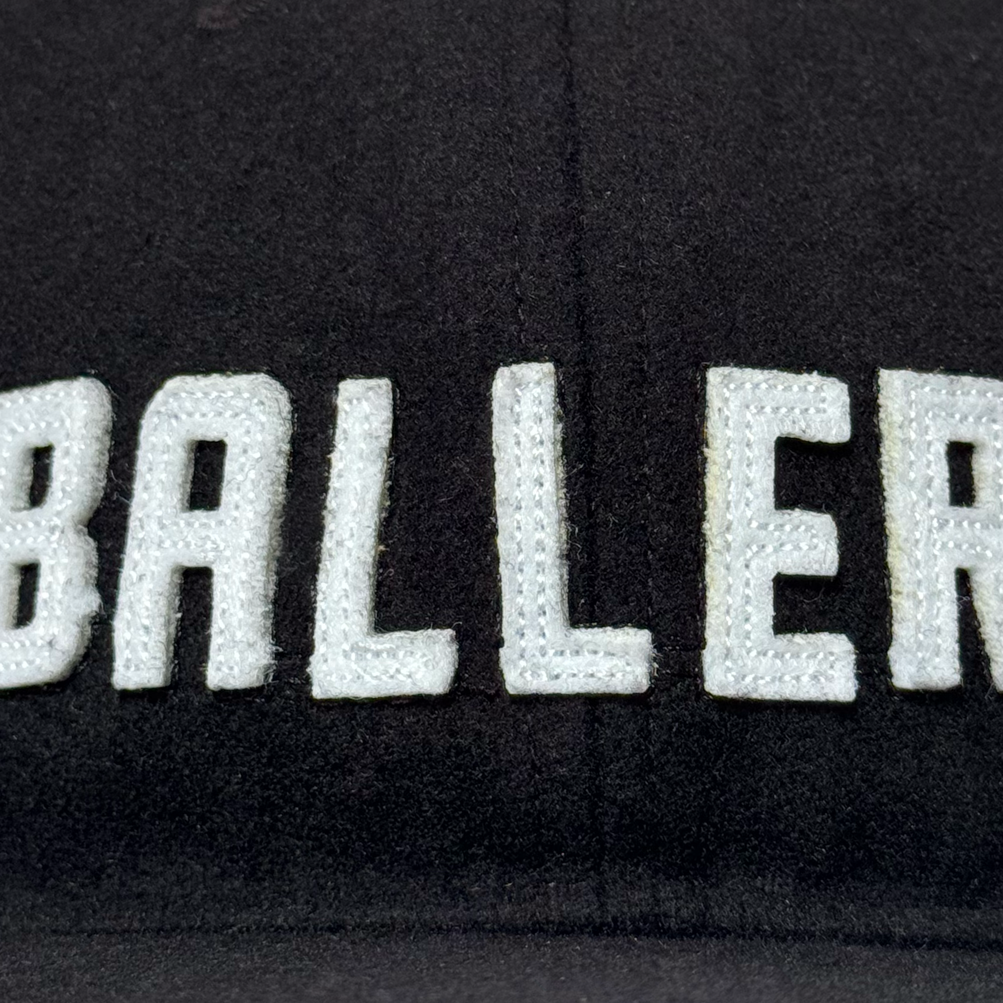 Close-up of the Oakland Ballers Felt Applique Strapback hat featuring "BALLER" in large white letters on black polyester wool blend fabric, showcasing detailed stitching and texture from the Oakland Ballers brand.