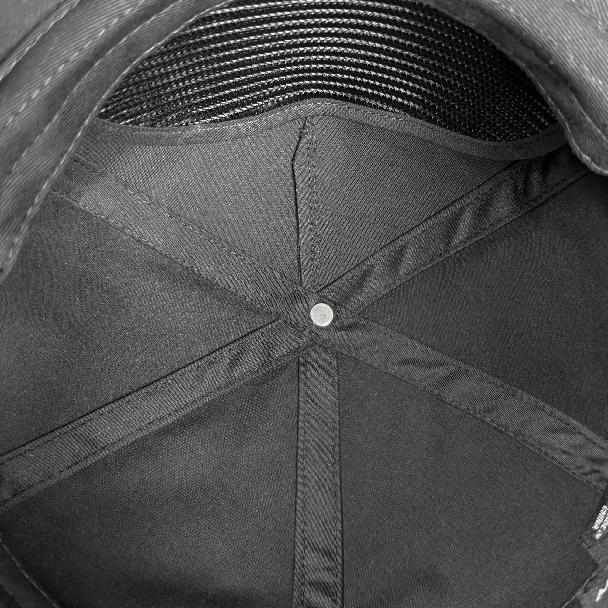 The image shows the inside of an Oakland Ballers Classic Golf Cap. It features a small round metal button where fabric panels meet, with black star-like stitching and a textured sweatband lining the edge, highlighting its sturdy craftsmanship.
