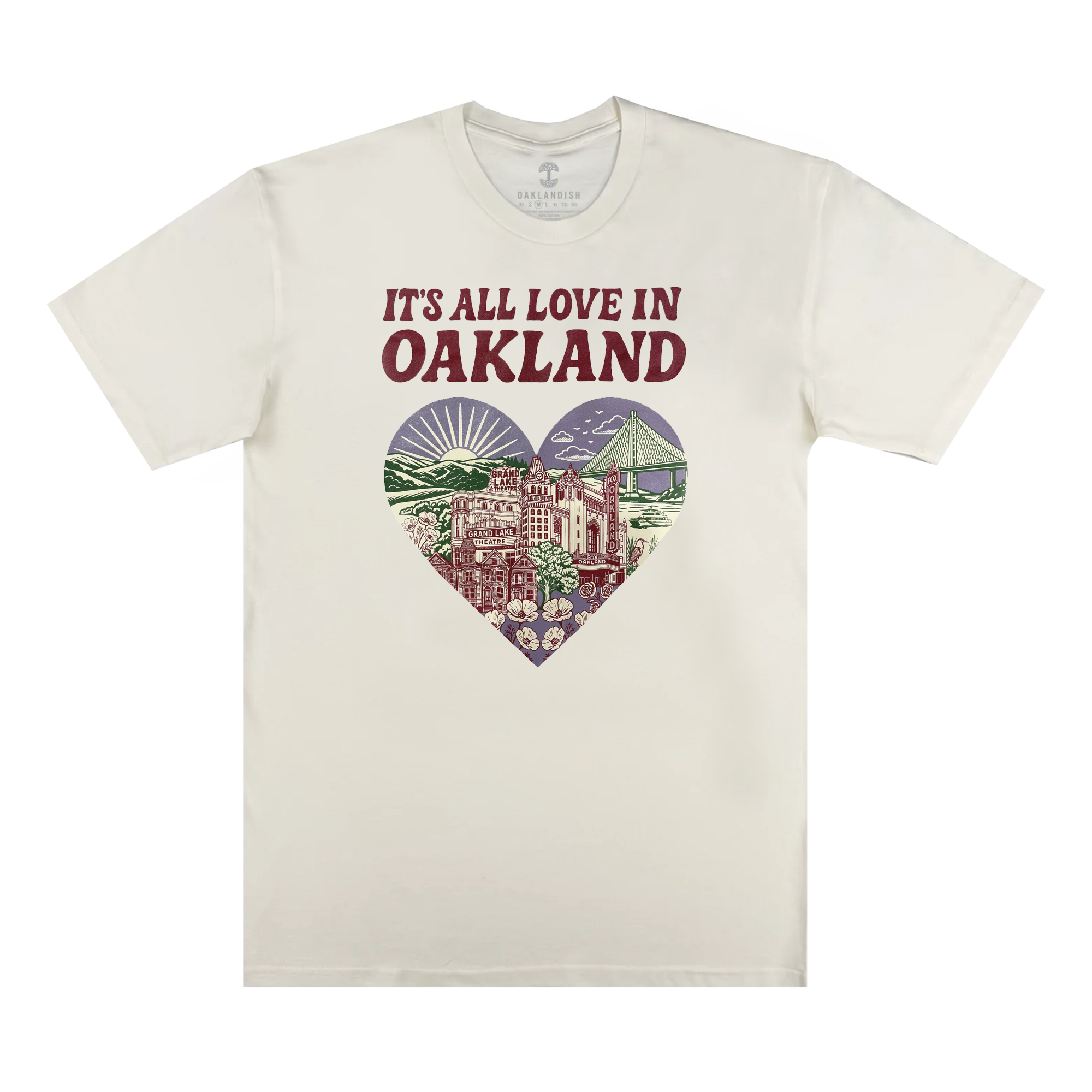 The Oaklandish It's All Love in Oakland Tee is a cream, 100% cotton shirt with bold "IT'S ALL LOVE IN OAKLAND" text above a heart graphic featuring Oakland landmarks, flowers, the sun, and cityscape in green, purple, and red.