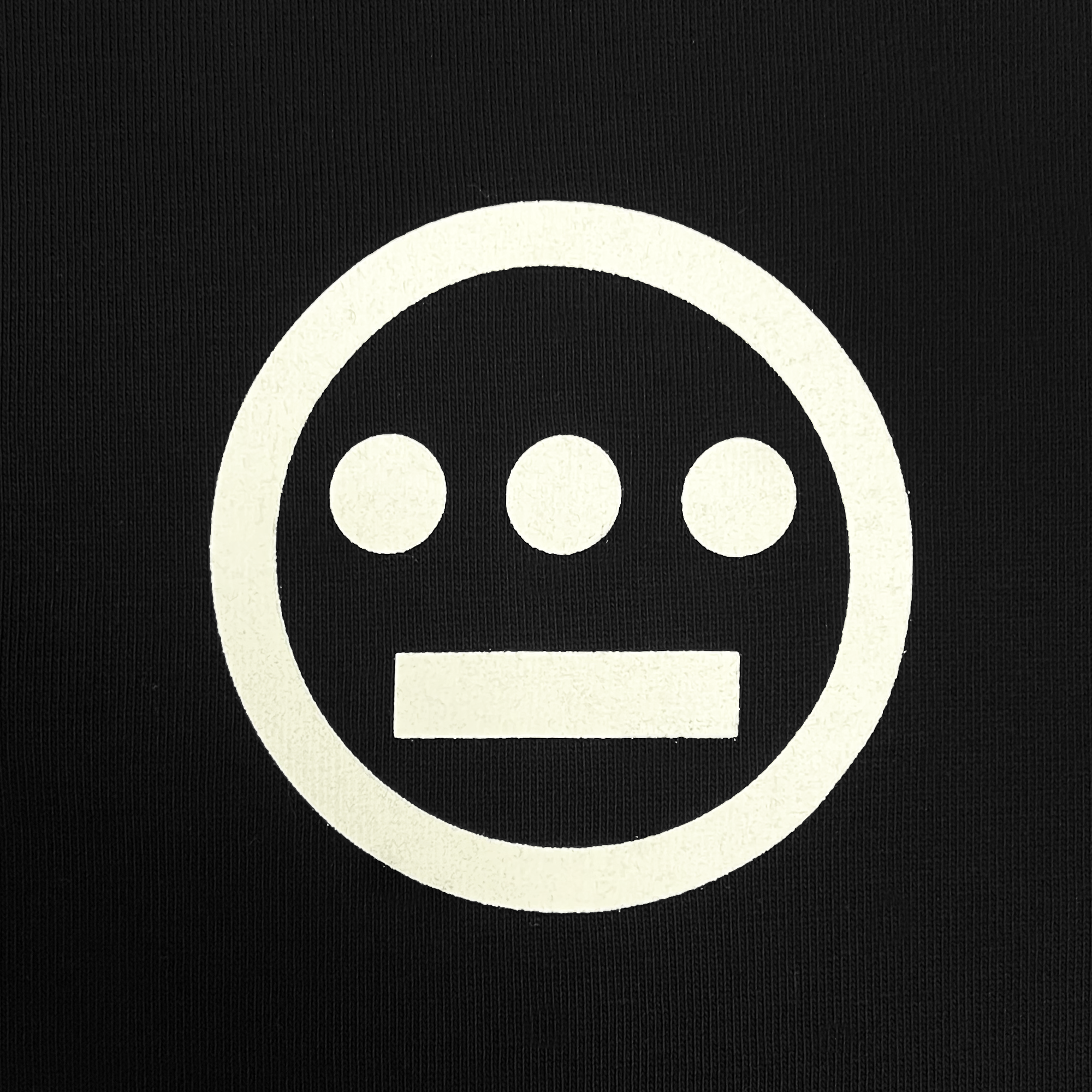The Hiero Heavy Button-up Baseball Jersey from Hieroglyphics features a black backdrop adorned with a white, minimalist face-like design that evokes hieroglyphic imagery. The symbol includes a white circle encircling three smaller, filled circles arranged horizontally at the top and a single horizontal line at the bottom, giving it the look of a simplistic facial expression.