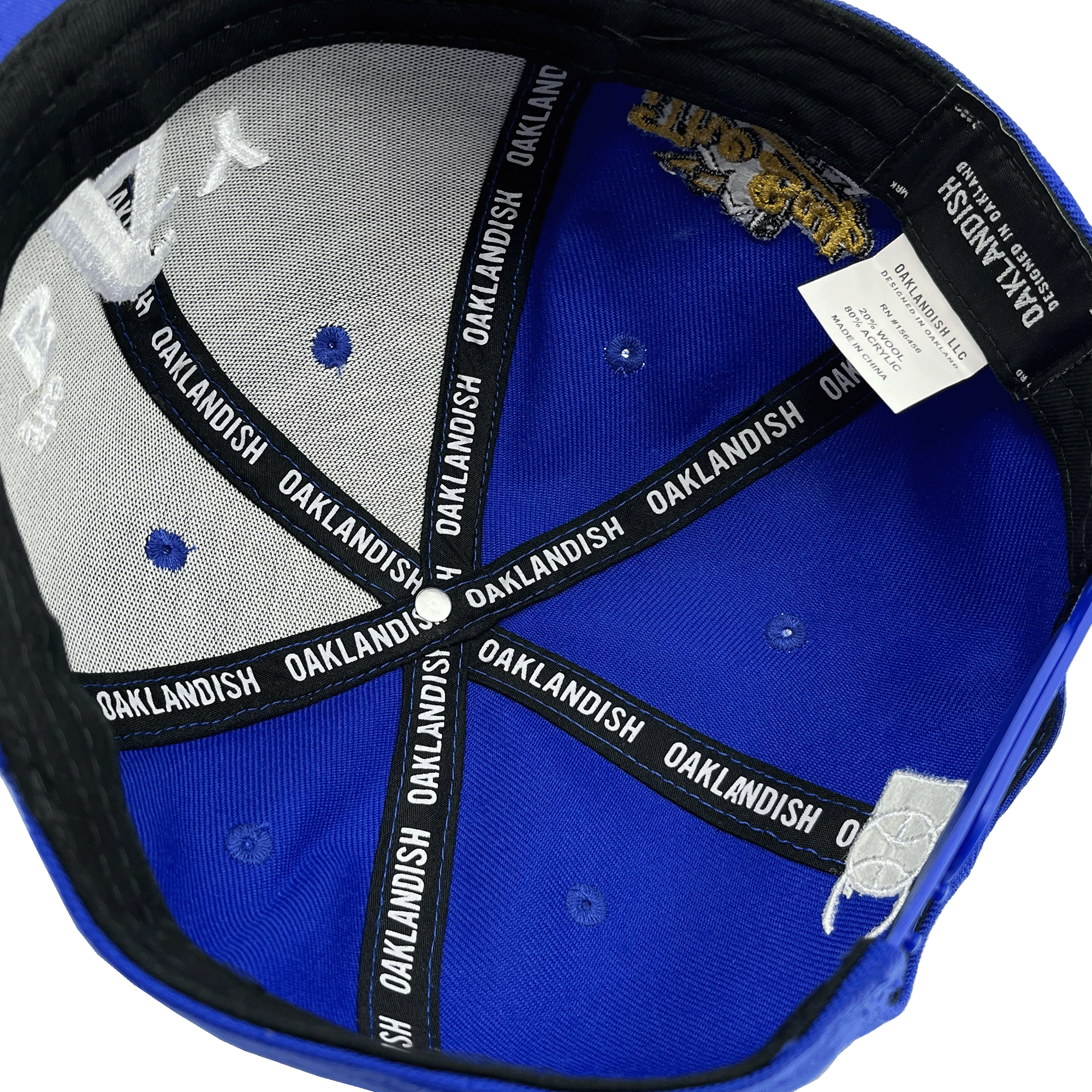 Inside crown view of black taping with Oaklandish wordmark on repeat inside a royal blue cap.