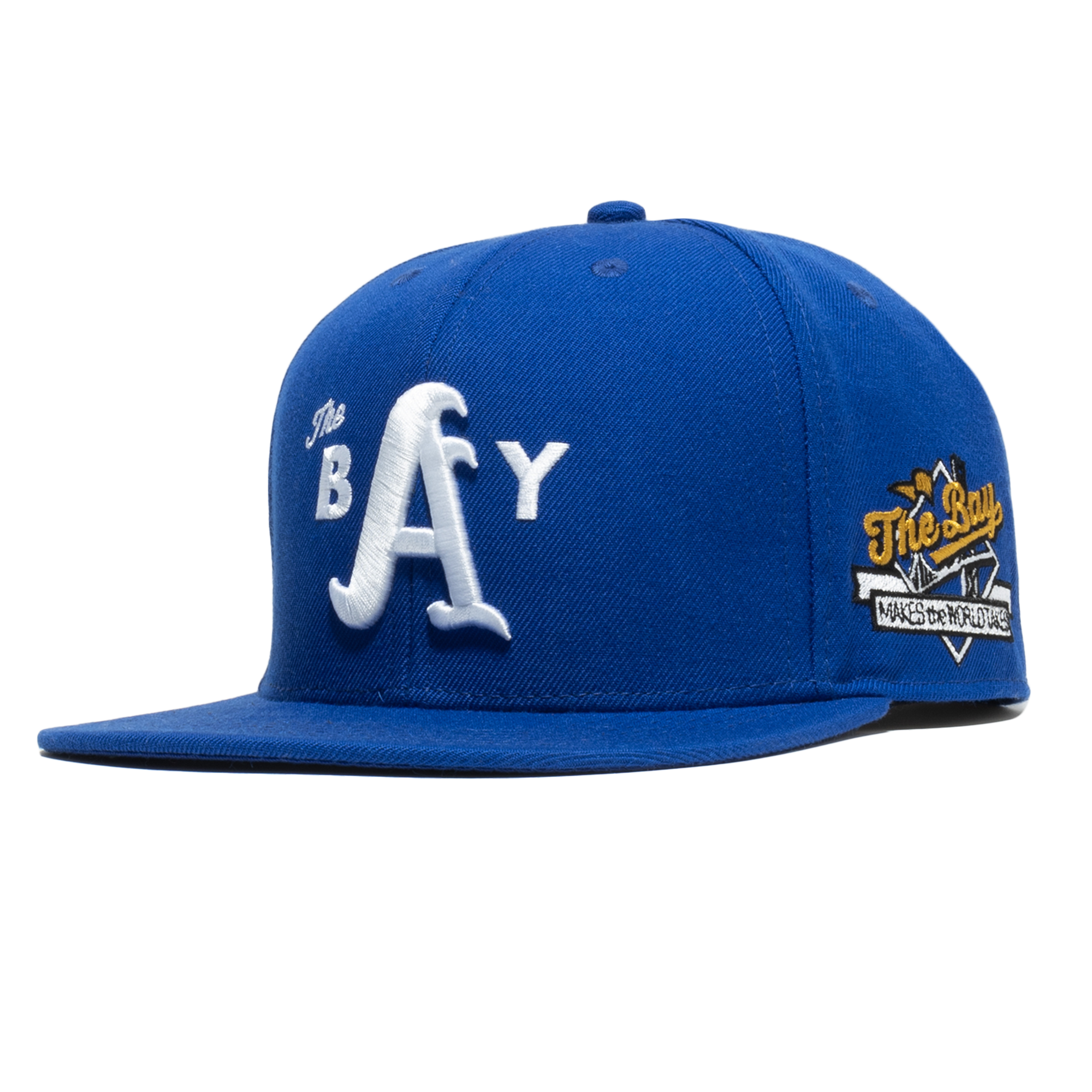 Side-angled front view of a Royal blue hat with 3D white embroidered The Bay logo on the crown & full-colored The Bay Makes, The World Takes detail on the wearer’s left side. 