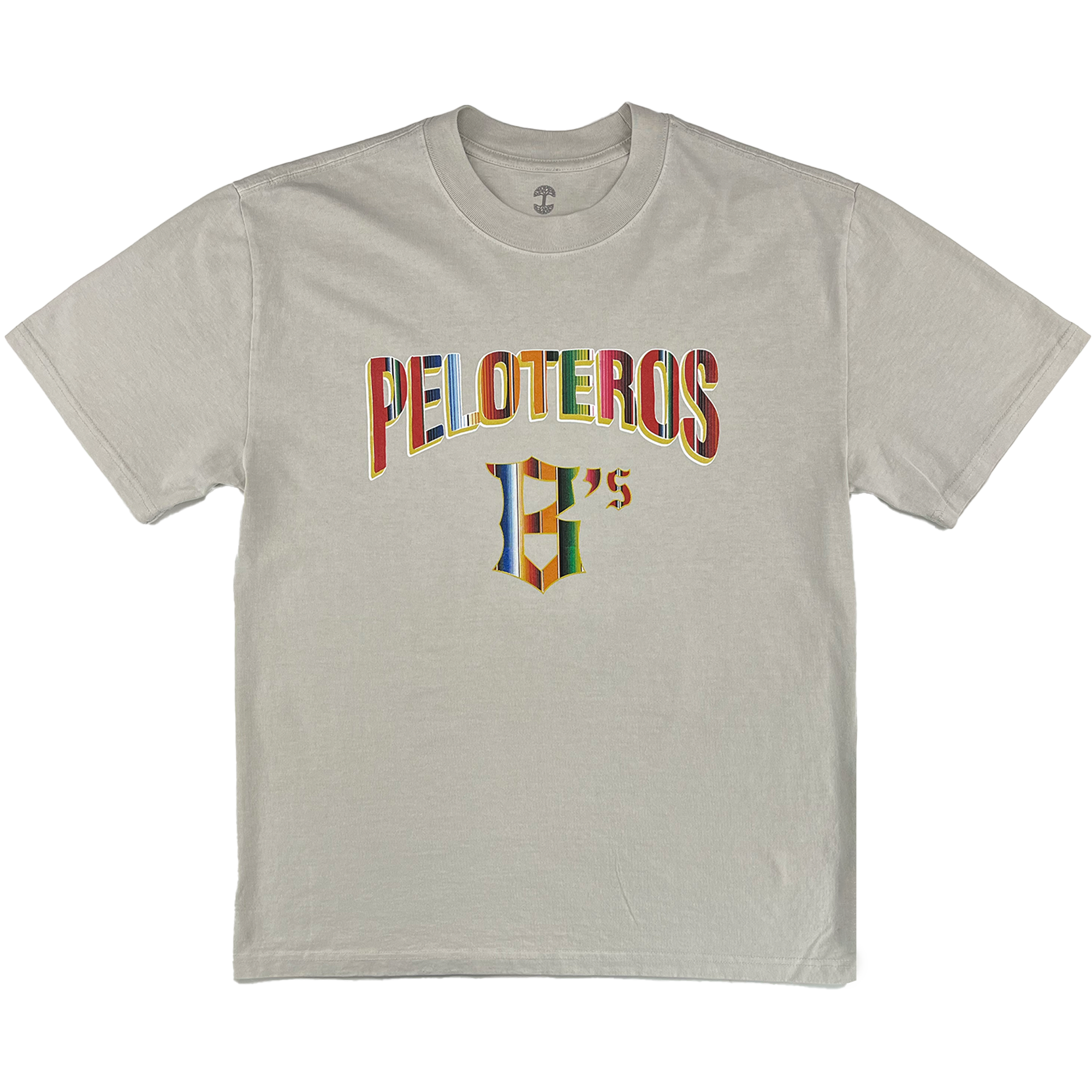 The Oakland Beisbol Heavy Tee by Oakland Ballers is a light beige shirt featuring "PELOTEROS" in large multi-colored letters above a stylized "G's" logo, inspired by the team, centered on the front and shown flat on a white background.