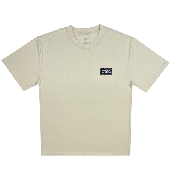 Front flat image of heavy cotton ecru t-shirt with embroidered Oaklandish woven label on wearer's left chest.