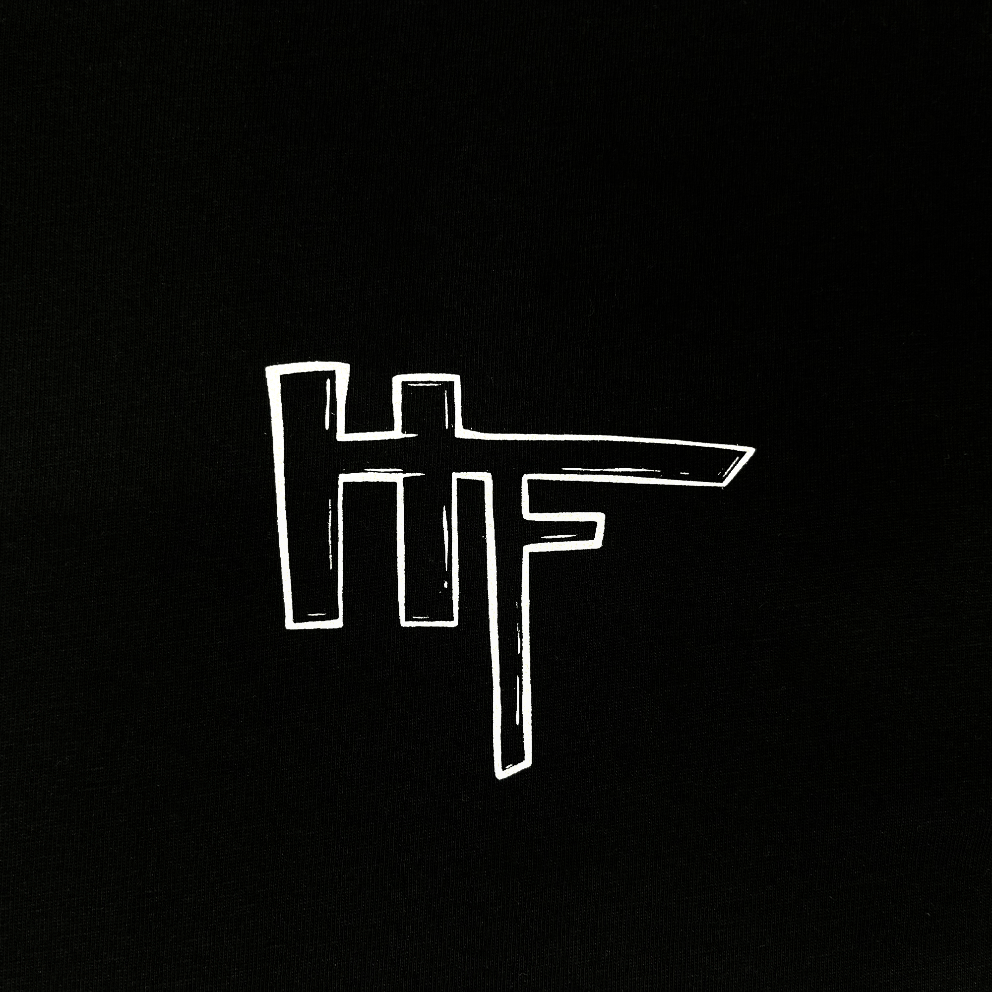 Close-up of HellaFutures logo by Oakland artist on the chest of a black t-shirt.