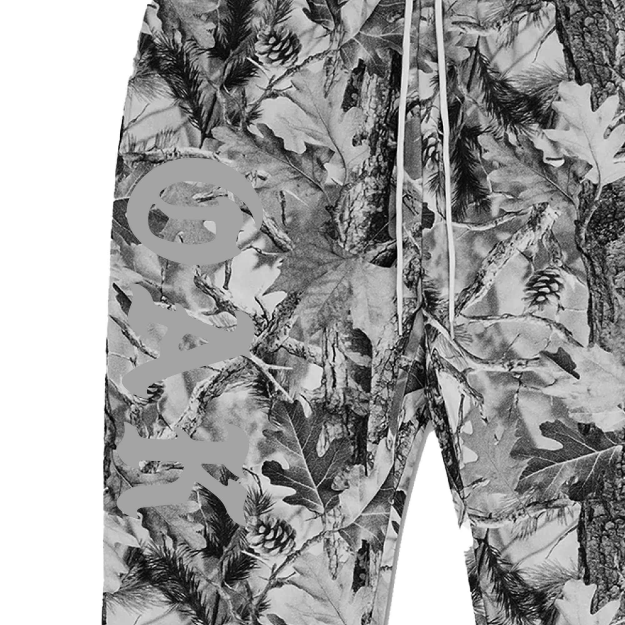 A close-up of the Cork Pant by Oaklandish in 100% cotton, showcasing a grey wood camo pattern with leaves, branches, and pine cones. "OAK" is printed vertically on the left leg and white drawstrings detail the waistband.