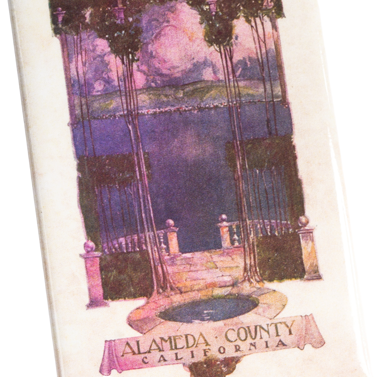 This Alameda County Magnet by Oaklandish features a vintage-style illustration of a terrace with pillars, offering views of water and mountains. Ornate columns, lush greenery, and a colorful sky frame the scene, while a decorative banner at the bottom reads “Alameda County California.” Perfect as an East Bay souvenir, this magnet is an ideal addition to your refrigerator or collection.