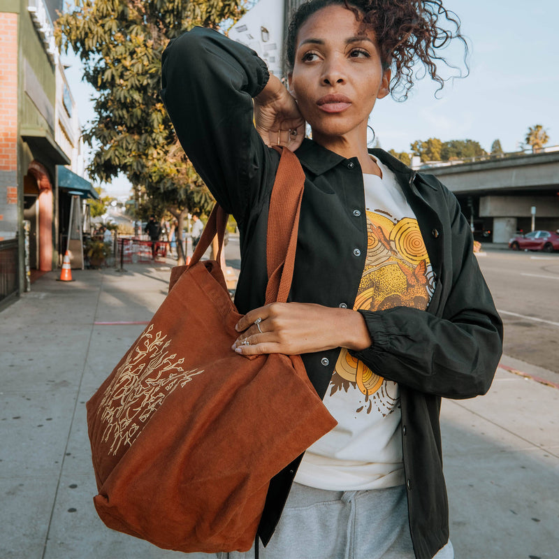 Female model wearing ginger growth tote.