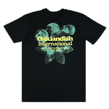 Backside of a black t-shirt featuring a green and yellow Oakland International graphic with a caption celebrating global diversity since 2000. 