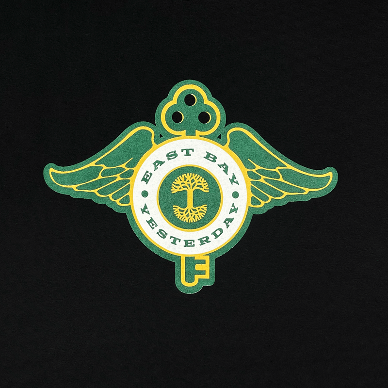 Close-up of the collaborative logo graphic from the historic Key System streetcars and Oaklandish on the front chest of a black t-shirt.