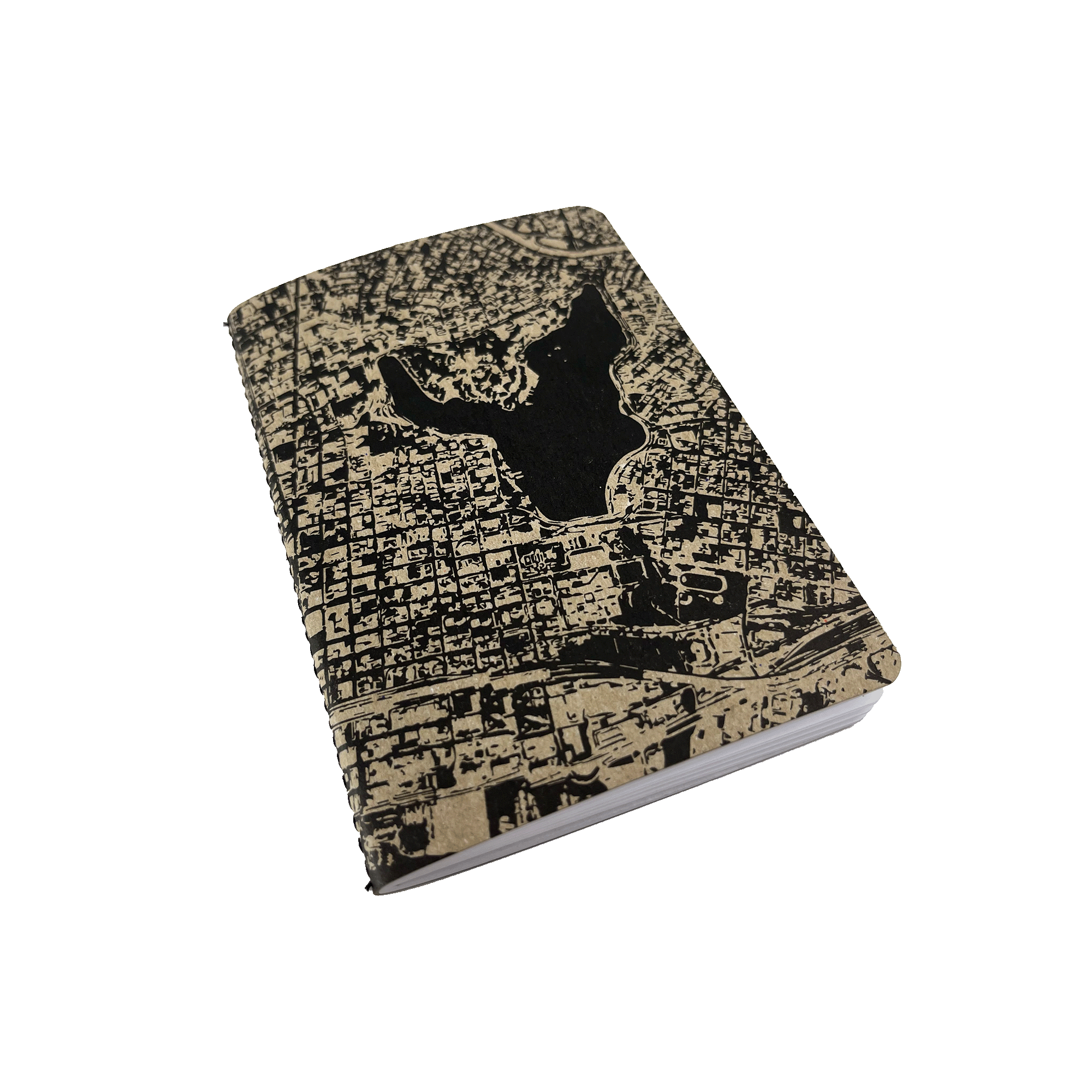 The Aerial Map Mini Notebook by Never Elsewhere, featuring a closed black and beige letterpress cover with a detailed map-like design, displays a grid of streets and a significant large central park or body of water. The edges are slightly rounded, creating an elegant look as it lies against a plain white background.