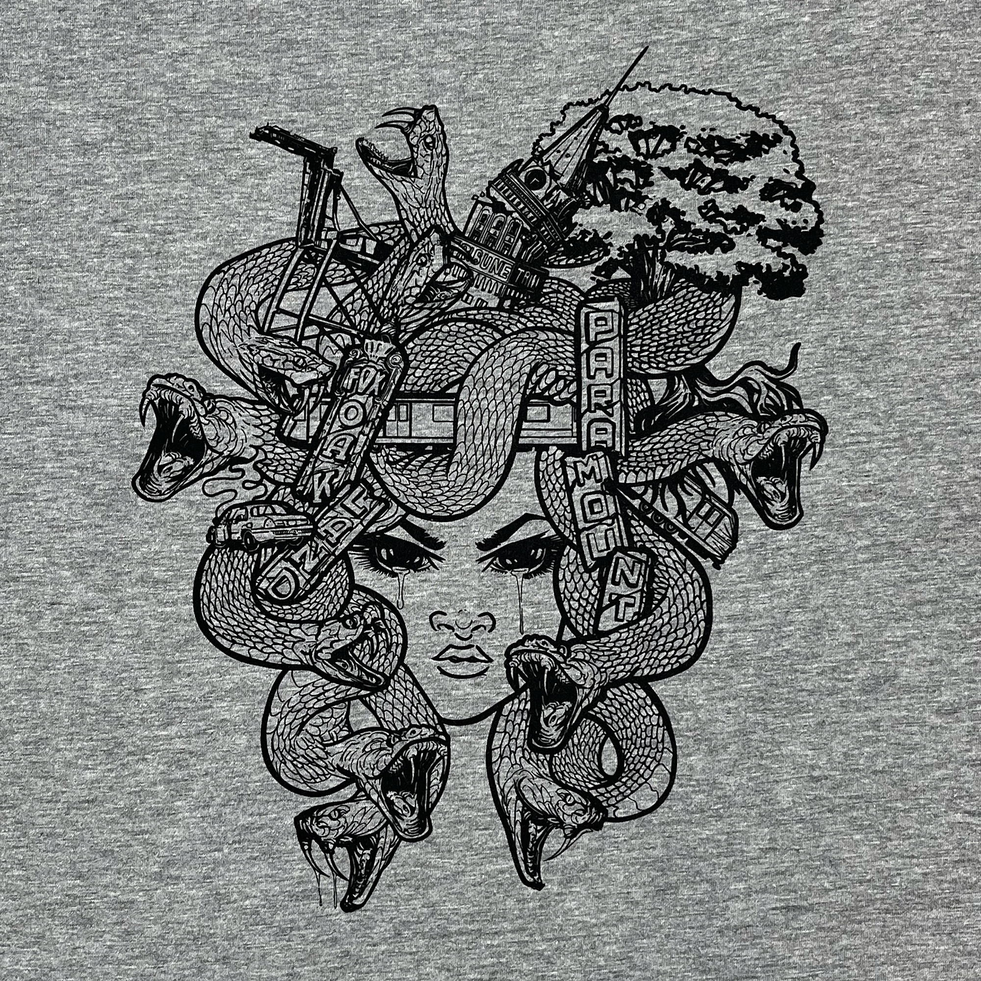 Detailed close-up of Medusa monster of the mind graphic on the front chest of an athletic grey t-shirt.