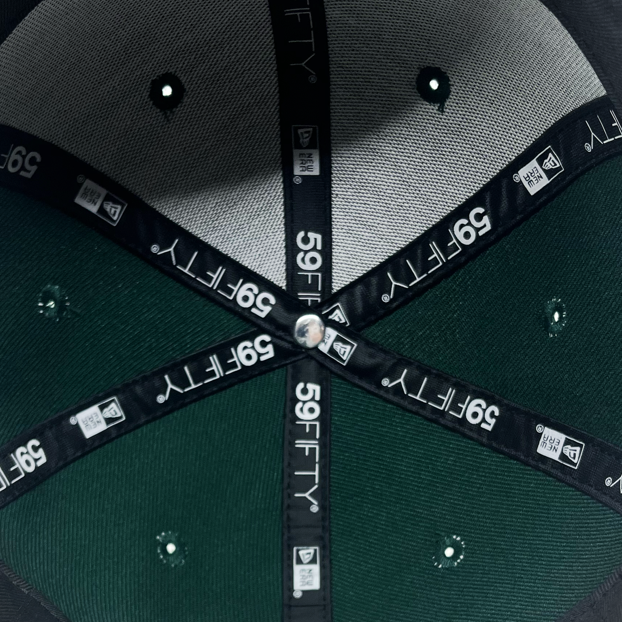 Detailed inside view of forest green 59fifty fitted hat with 59Fifty and New era logos on taping.
