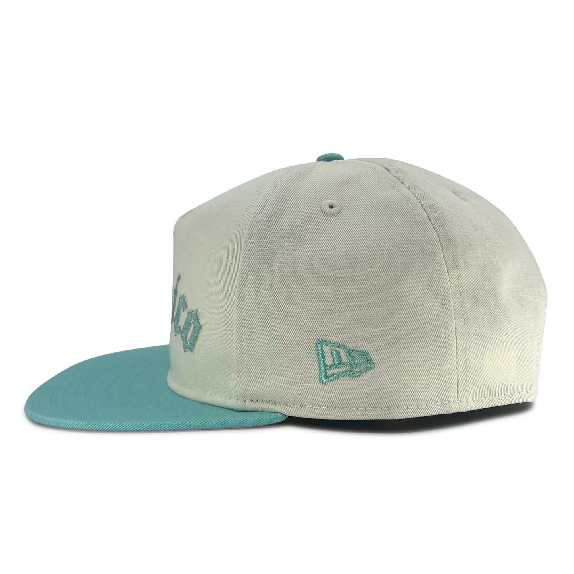 Side view of cream New Era golfer hat with embroidered Mexico , floral design, and New Era flag logo on wearer's left side.