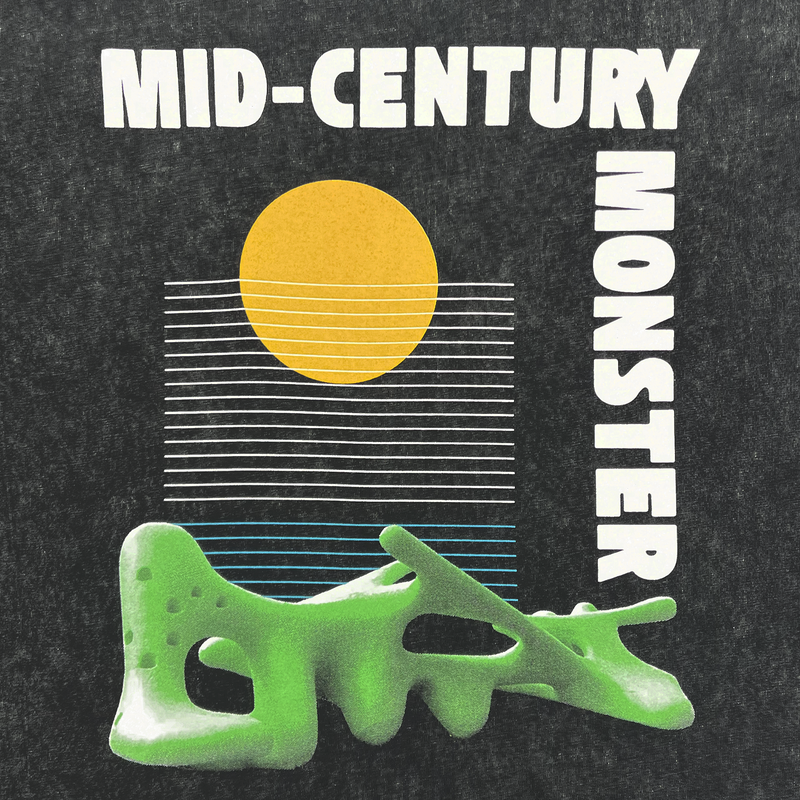 Detailed close-up of mid-century monster graphic from Oaklands Marci Iron Works on the front chest of a black stone t-shirt.