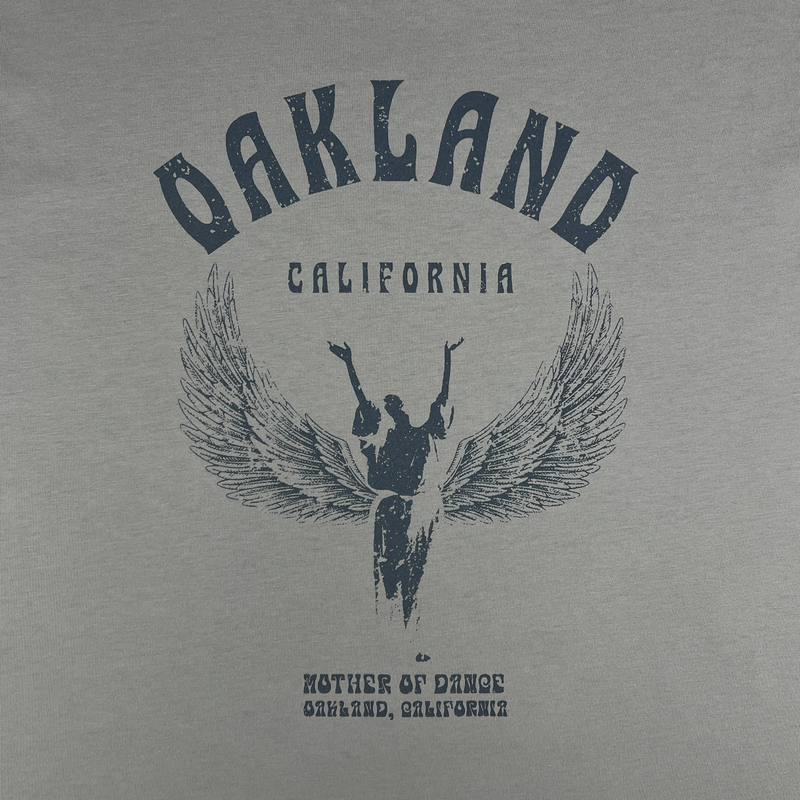 Detailed close up of Oakland California graphic celebrating Isadora Duncan, pioneer of modern dance on a dust-colored t-shirt.