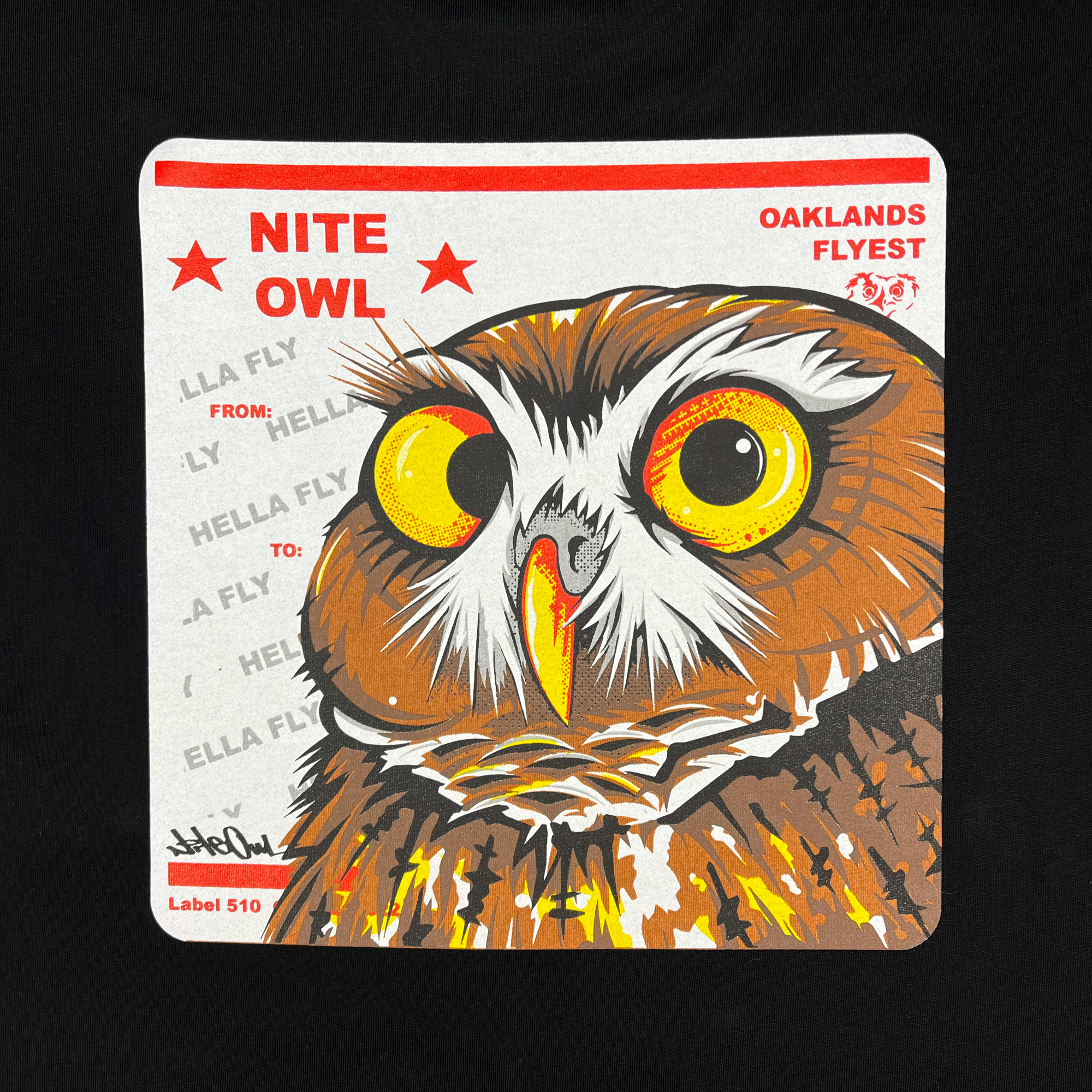 Close-up a graphic with a Burrowing Owl designed by Oakland Artist Nite Owl on a USPS sticker on a black t-shirt.