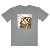 Backside view of a grey t-shirt featuring a graphic with a Burrowing Owl designed by Oakland Artist Nite Owl on a USPS sticker.